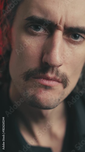 Agreeing, nodding, approving, direct gaze: Young attractive man with a mustache and long hair, showcasing deep emotions through powerful facial expressions.