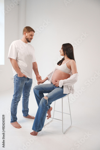 Expecting couple sharing a tender moment in a studio