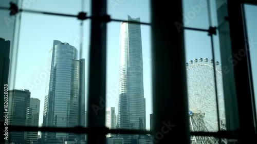 City skyline view featuring a large Ferris wheel against a clear sky