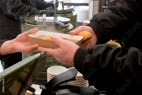 Chef cook serving nourishing hot meals soup for fishermen on fishing competition. Men in camp eating in break during catching fish. Outdoor winter activity hobby leisure recreation kind of sport.