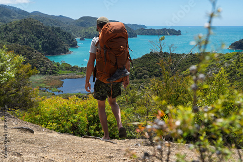Hiker wearing flip flops backpacking Abel Tasman Coast Track, New Zealand