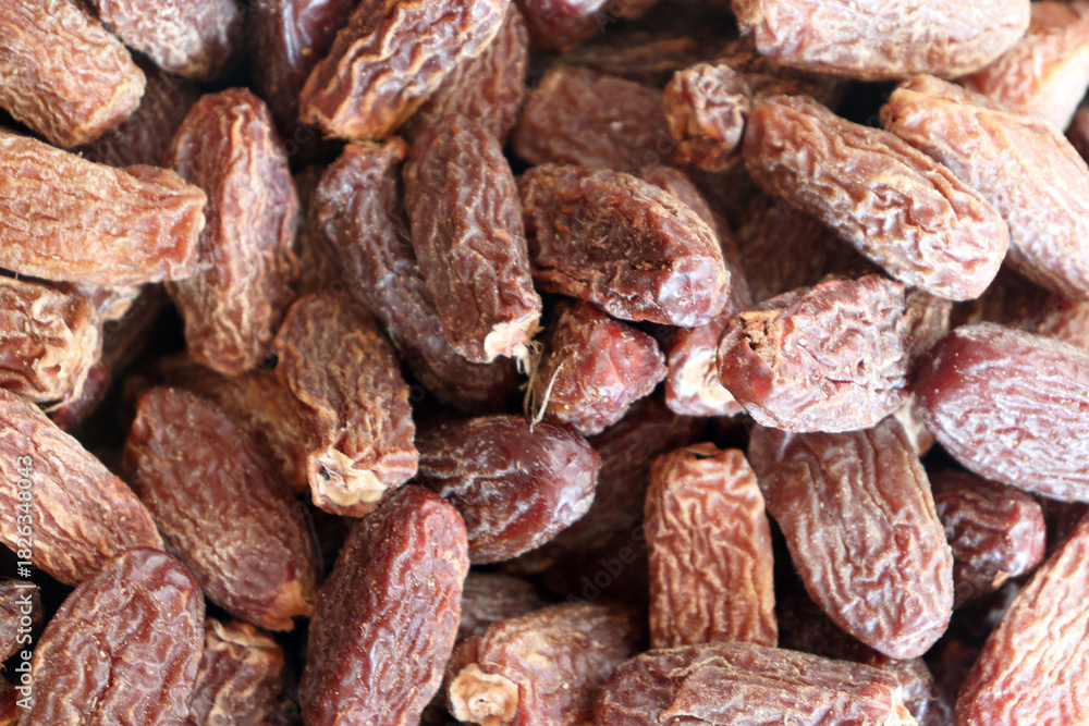 Obraz premium Dried dates close up showing dense pile with wrinkled skins and natural colors