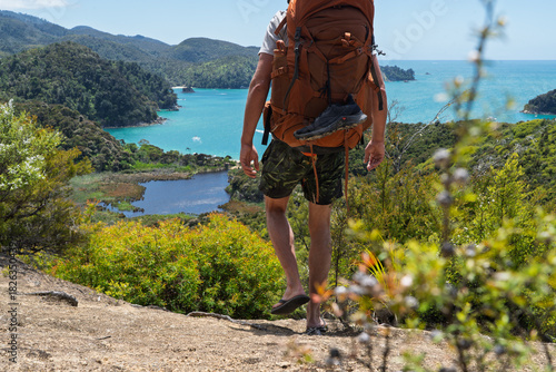 Canvas Print Hiker with backpack and flip flops walking Abel Tasman Coast Track, NZ