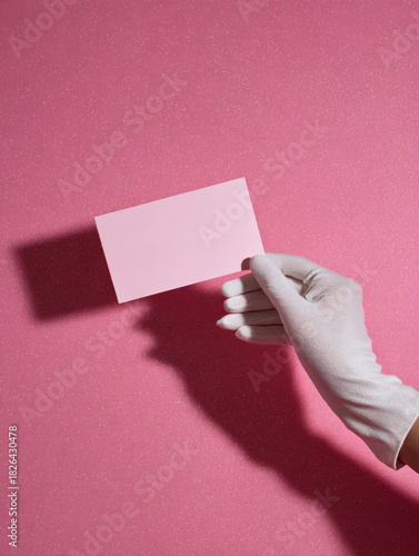 Glam hand in white glove holding blank pink card for stylish promotional branding