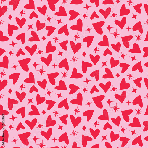 Red hearts with retro atomic starbursts seamless pattern on powder pink background. For valentine’s day wrapping paper, fabric and greeting cards.