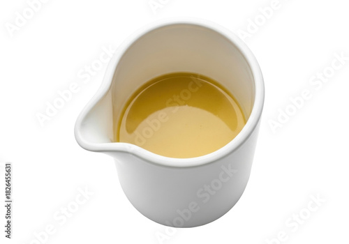 Isolated gravy boat filled with flavorful broth of clear consommé close up view, food photography