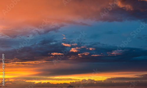 Radiant evening sky illuminated by warm sunset glow through drifting clouds