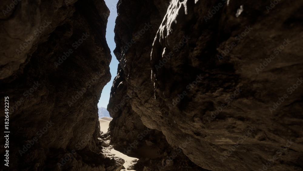 Naklejka premium Sunlight shines through a narrow canyon, with towering rock formations on either side. Sandy ground leads deeper into the beautiful desert scenery, inviting adventure.