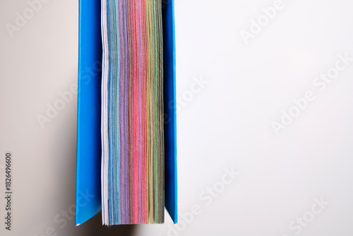 Close-up top view of colorful pages of a diary, white background