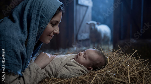 Fototapeta Naklejka Na Ścianę i Meble -  Serene nativity moment with Mary lovingly gazing at baby Jesus wrapped in cloth, sleeping on hay, inside a stable.