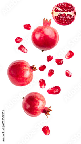 Fresh pomegranates and vibrant arils falling, creating a dynamic composition on a clean white background