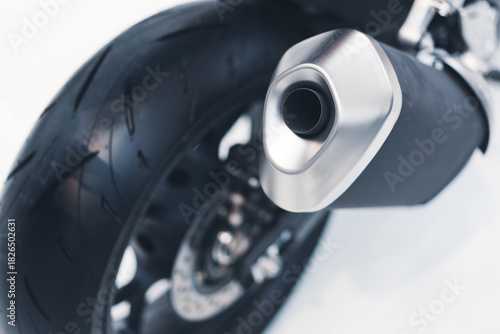 Closeup of a sleek modern motorcycle exhaust pipe and rear tire design