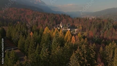 Aerial panoramic view of Peles Castle in autumn mountains at sunset