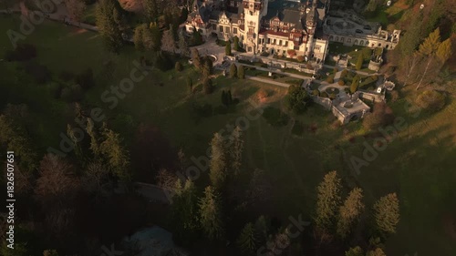Aerial reveal of Peles Castle in Romania at sunset during fall