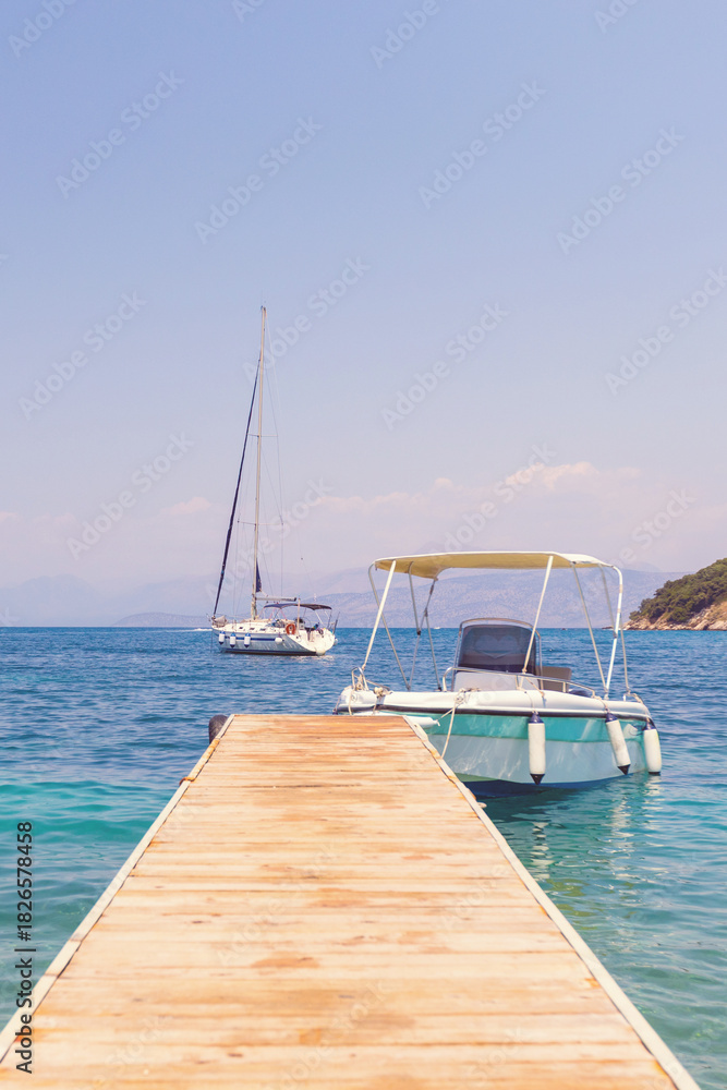 Fototapeta premium Wooden jetty leading to boats and calm sea on a sunny summer day