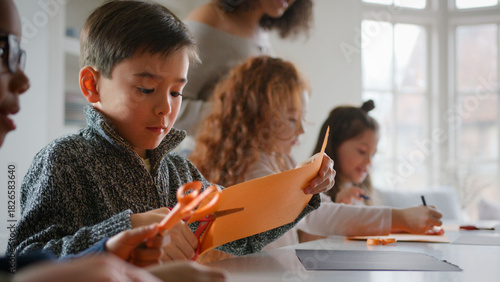 Group Of Children At Home With Mother Having Fun Making Craft Together