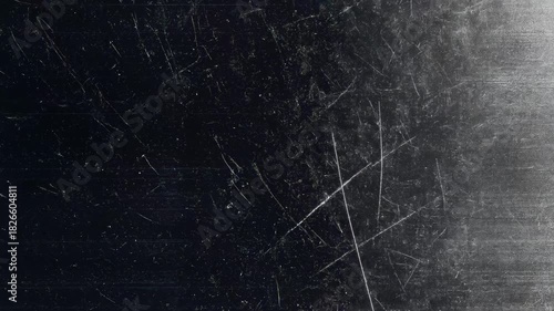 A scratched surface with a grayish texture, featuring subtle light reflections and a watermark.