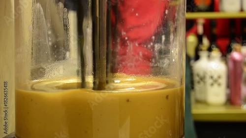 Close-up view of fresh juice or smoothie being blended in a transparent container