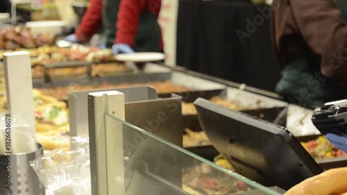 Close-up of a customer making a contactless payment with a bank card at an outdoor food fair.