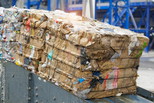Фотография Compressed cardboard and plastic bales in recycling facility, eco friendly facto