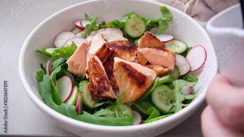 Salad with grilled salmon, cucumber, radish, capers, arugula and tahini dressing.