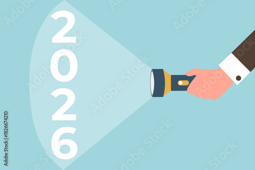 Analysis and planning of future projects in coming year, development of strategies for achieving high results, construction of course of business development, hand shines a flashlight on the year 2026