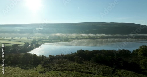 Flying over a calm and misty lake in Yorkshire Dales