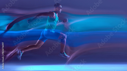 Foto Runner captured mid-stride in neon lighting with dynamic motion trails