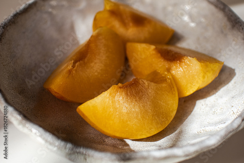Peach on a plate. Pieces of fresh juicy peach on a plate.