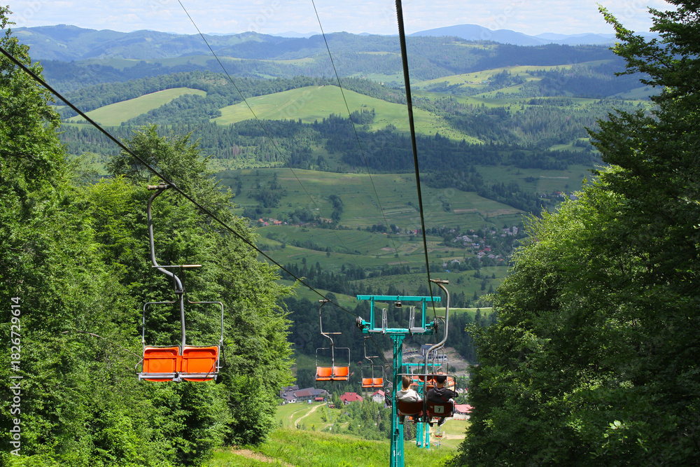 Fototapeta premium Chairlift Descent with Scenic Mountain Views