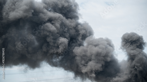 Dramatic billowing dark smoke against a cloudy sky