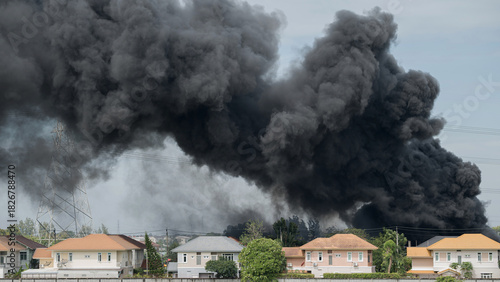 Dramatic plume of black smoke billowing over residential neighborhood