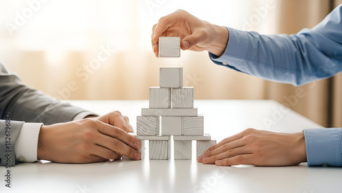 Strategic partnership building a business with wooden blocks, symbolizing growth and success, teamwork and collaboration, corporate planning, and financial stability