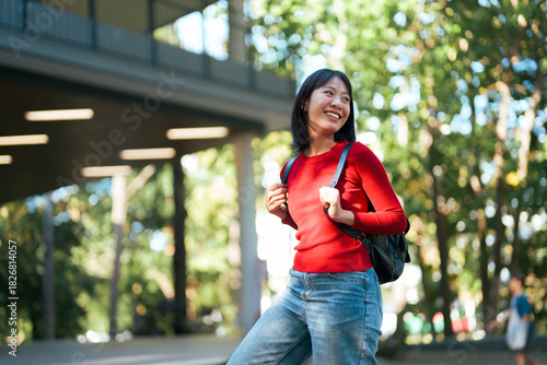 Young Asian student walking happy on college campus