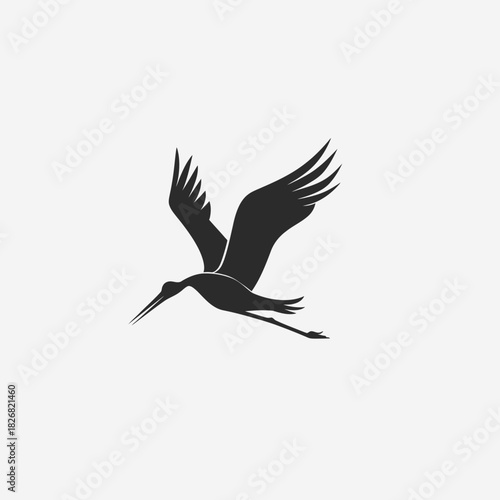 Elegant black silhouette of a flying stork or crane. Minimalist vector graphic icon representing bird flight and freedom.