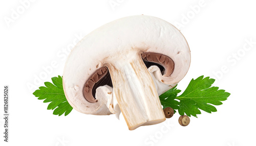 Close-up of a halved white mushroom with a stem, parsley, and peppercorns on black