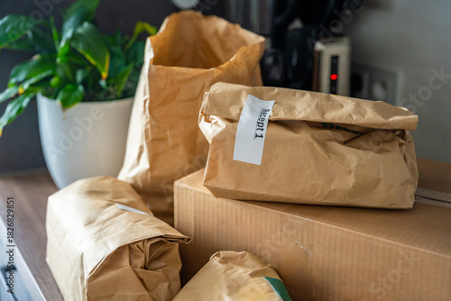 Close-up of brown paper bags with meal kits labeled Recept or Recipe. Subscription-based food delivery sorted by recipes.
