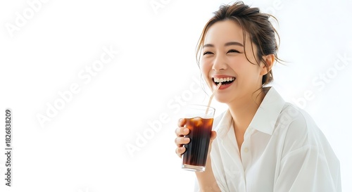 Joyful young asian woman in a white shirt laughing while enjoying a cold iced coffee drink isolated on white background