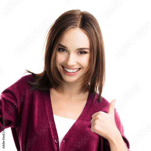 Portrait of beautiful woman showing pointing thumb up hand sign gesture, isolated against white background. Happy bright smile cute brunette hair girl wear red casual sweater. Square image