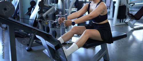 Φωτογραφία Muscular female athlete performing seated cable row exercise, targeting back mus