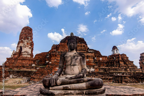 фотографія A statue of Buddha is sitting on a stone platform in front of a large building
