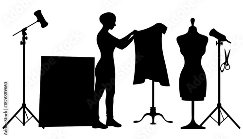 Silhouette of fashion designer with dress mannequin and studio lights