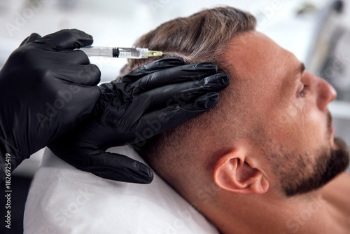 Wallpaper Mural Male undergoing hair restoration treatment with a syringe, showcasing the procedure in a modern clinic environment, emphasizing self-care and confidence enhancement Torontodigital.ca