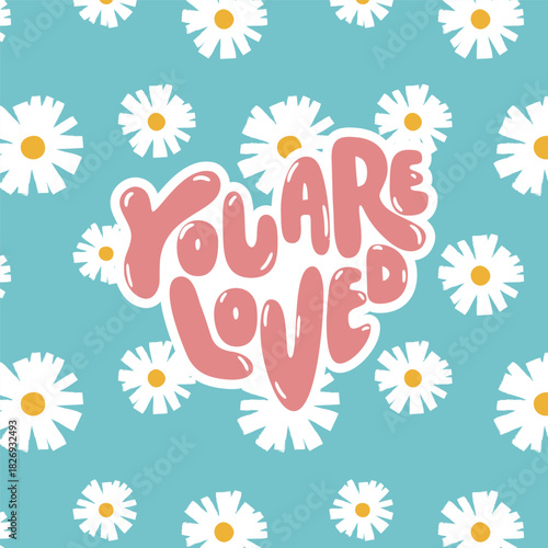 Soft and uplifting floral graphic with hand-lettered “You Are Loved” typography over a turquoise daisy pattern. A sweet, comforting statement perfect for girl’s casual kidswear and summer-themed print