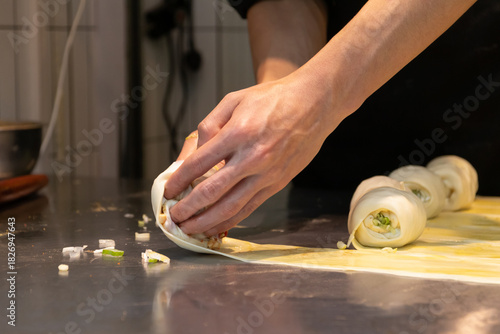 Tableau sur toile Chef hands rolled pastry dough on stainless table preparing (Guo Kui), crispy stuffed flatbread is truly scrumptious with flaky and crispy layers