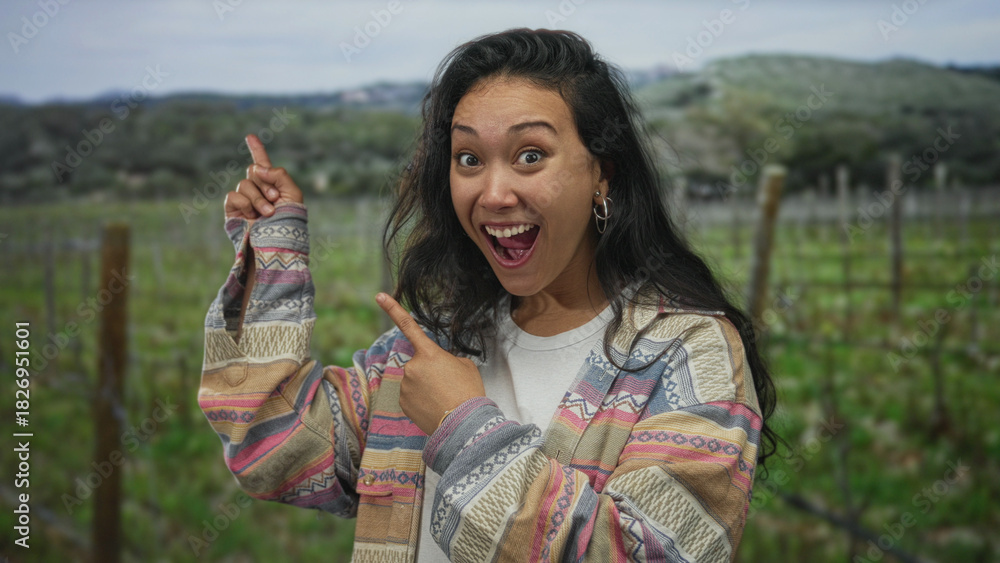 Naklejka premium Woman points finger with open mouth in forest wearing patterned jacket and hoop earring; excitement.