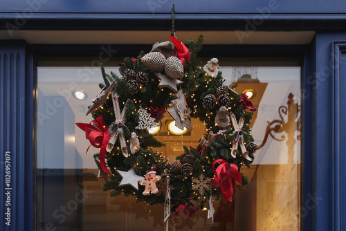 A wreath with red bows golden balls on the branches and on a glass door for Christmas