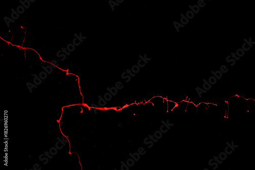 Red paint splash isolated on black background.