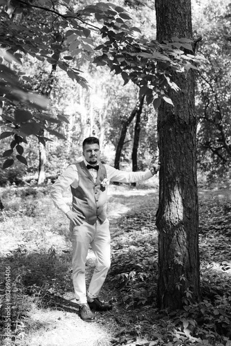 bald guy in a gray jacket on a background of tree