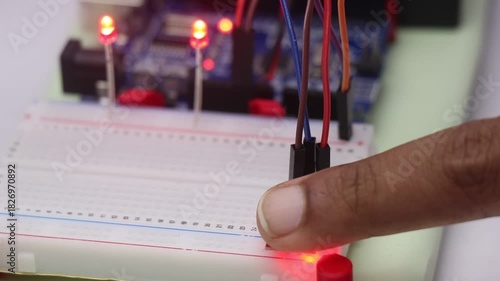 Touch sensor module connected to breadboard that when is touched is activating the red led on background controlled by a microcontroller